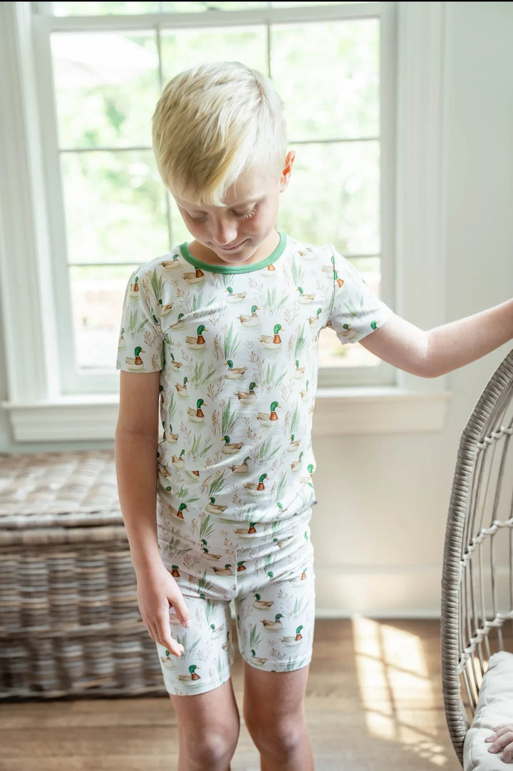 Toddler boy lounging in mallard duck bamboo pajamas, breathable two-piece sleepwear for summer.