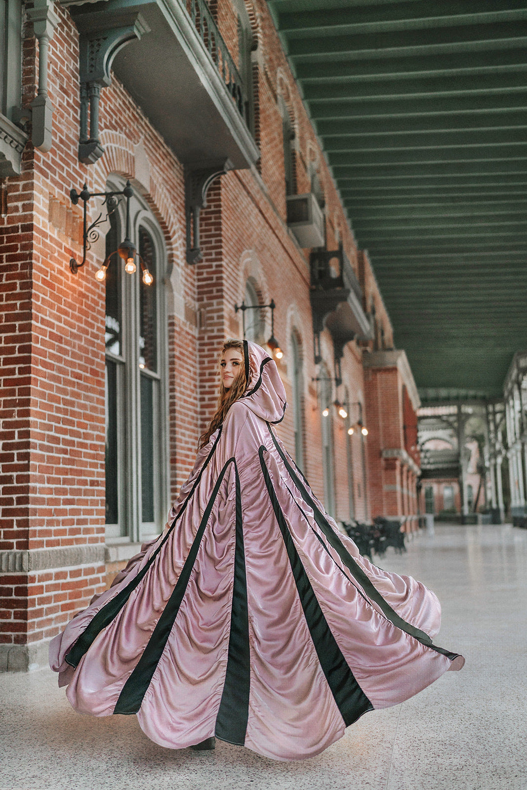 Mauve satin Coffin Cape fanned wide in motion, showing dramatic Gothic volume and contrasting black bands