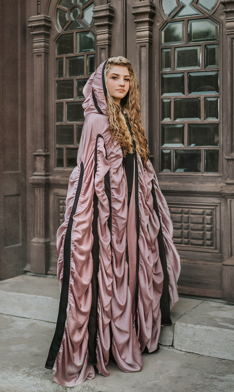 Back view of The Coffin Cape showing floor-length gathered mauve satin, black bands and draped hood for Halloween costume.