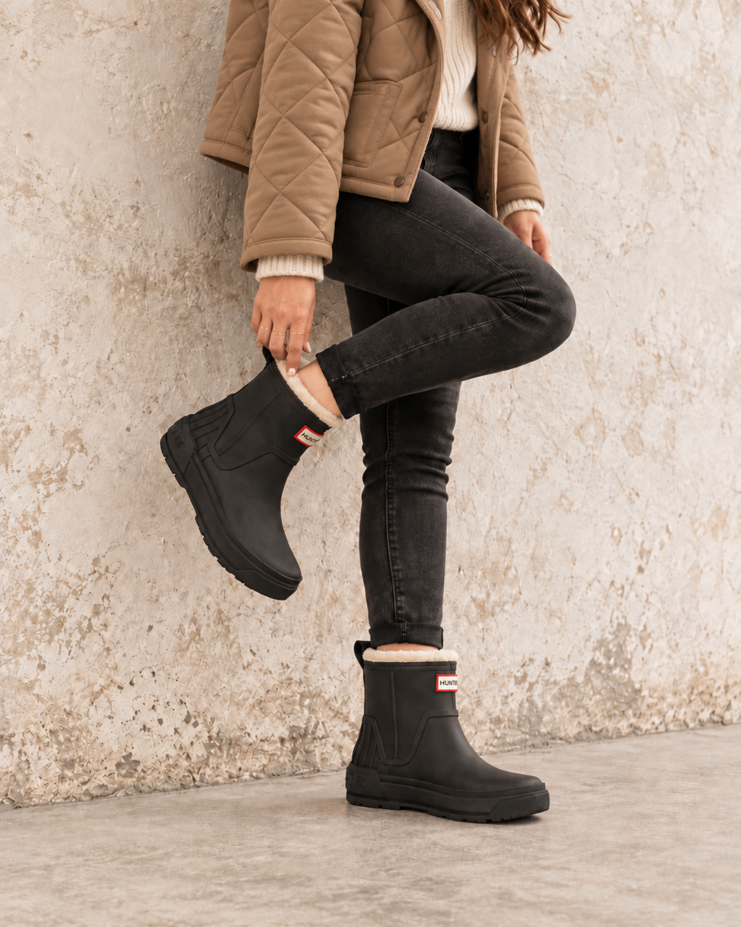 Hunter Women’s Willa black insulated waterproof booties styled with a shearling jacket and black jeans