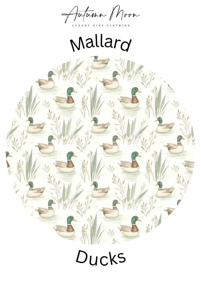 Close-up of mallard duck print on toddler bamboo zipper pajamas, featuring green ducks on a soft tan base.