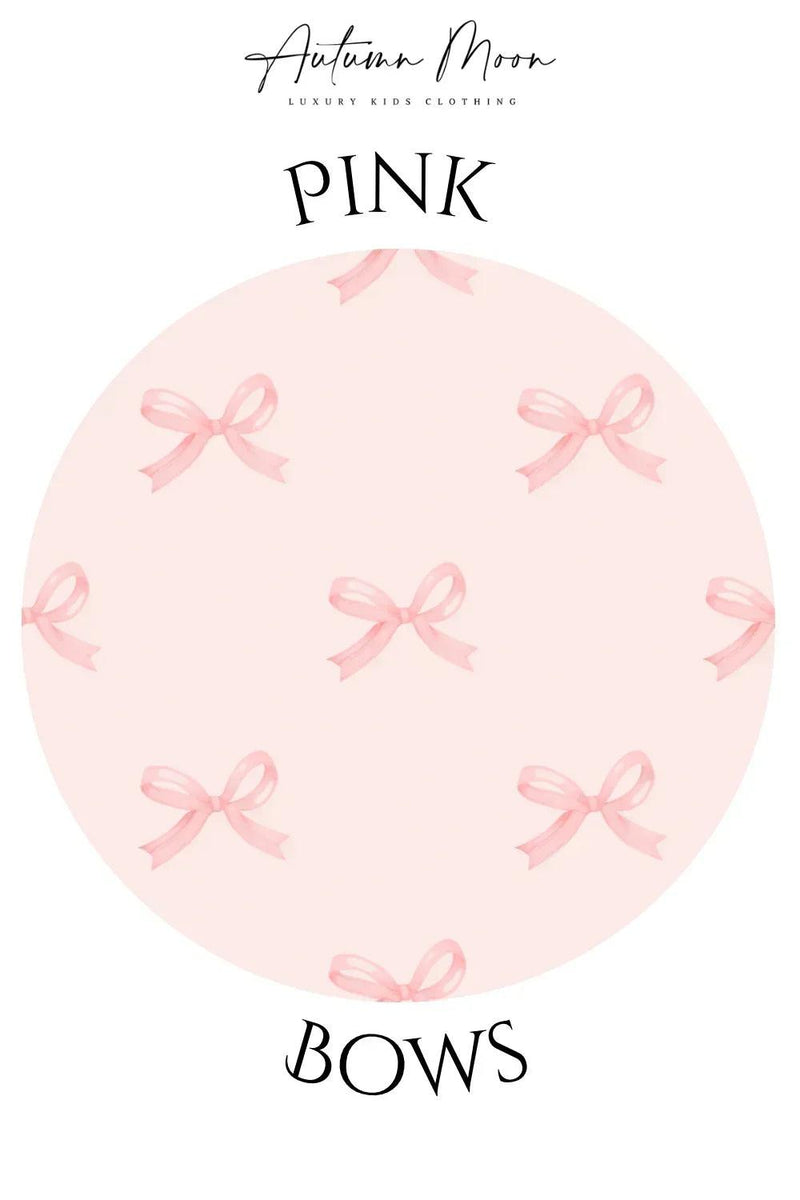 Close-up of pink bows graphic print on bamboo pajama top, soft light pink fabric with rose collar detail.
