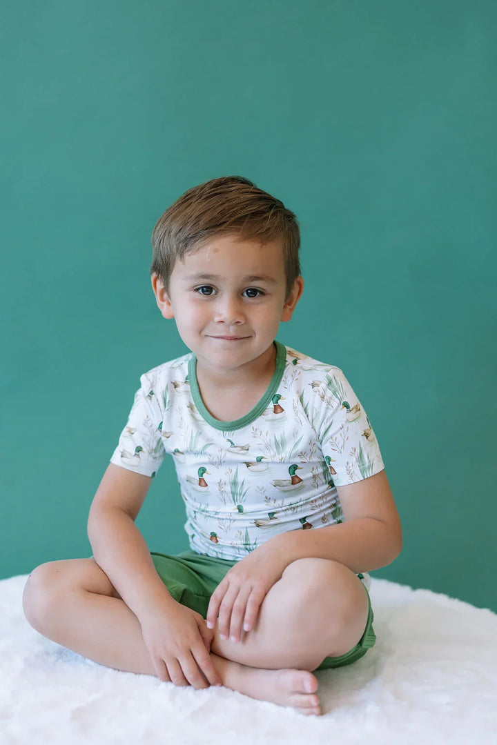 Child wearing mallard ducks bamboo T-shirt, short sleeve kids top styled for summer outdoor play.