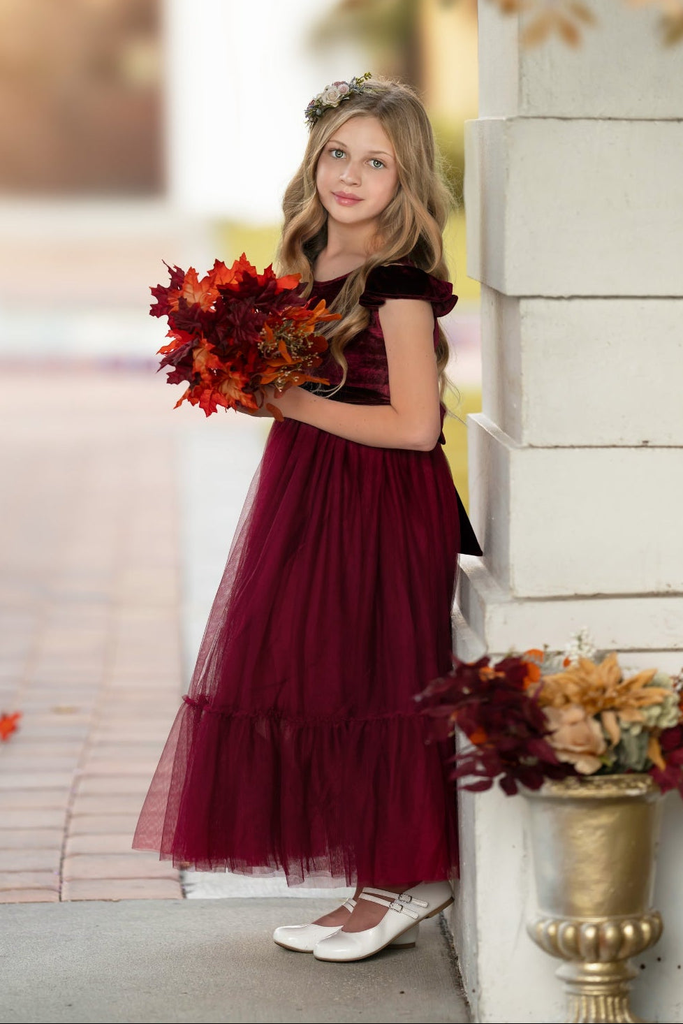 Bordeaux velvet flower girl dress with ruffle sleeves and plain tulle skirt, holding bouquet
