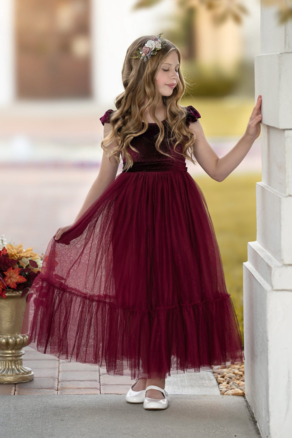 Side view of bordeaux velvet flower girl dress showing movement of full tulle skirt
