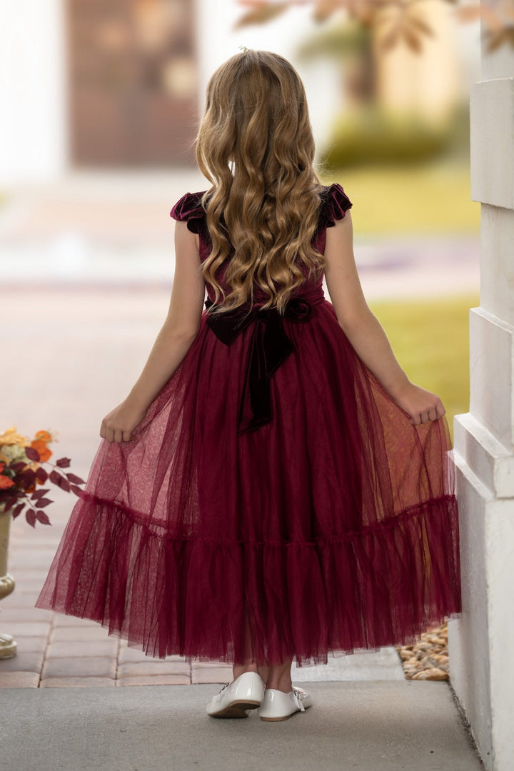 Back view of bordeaux velvet flower girl dress with full skirt and matching sash tie
