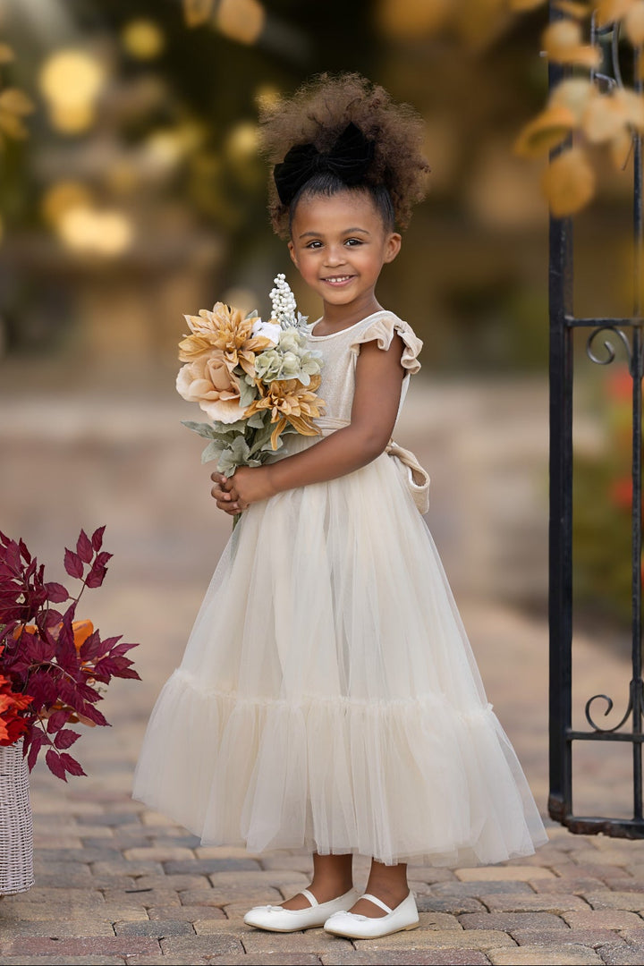 Marcella champagne velvet flower girl dress styled with bouquet, elegant neutral tone for weddings