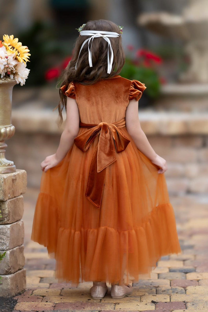 Back view of Marcella burnt orange velvet flower girl dress showing full bodice, sash bow, and layered tulle skirt