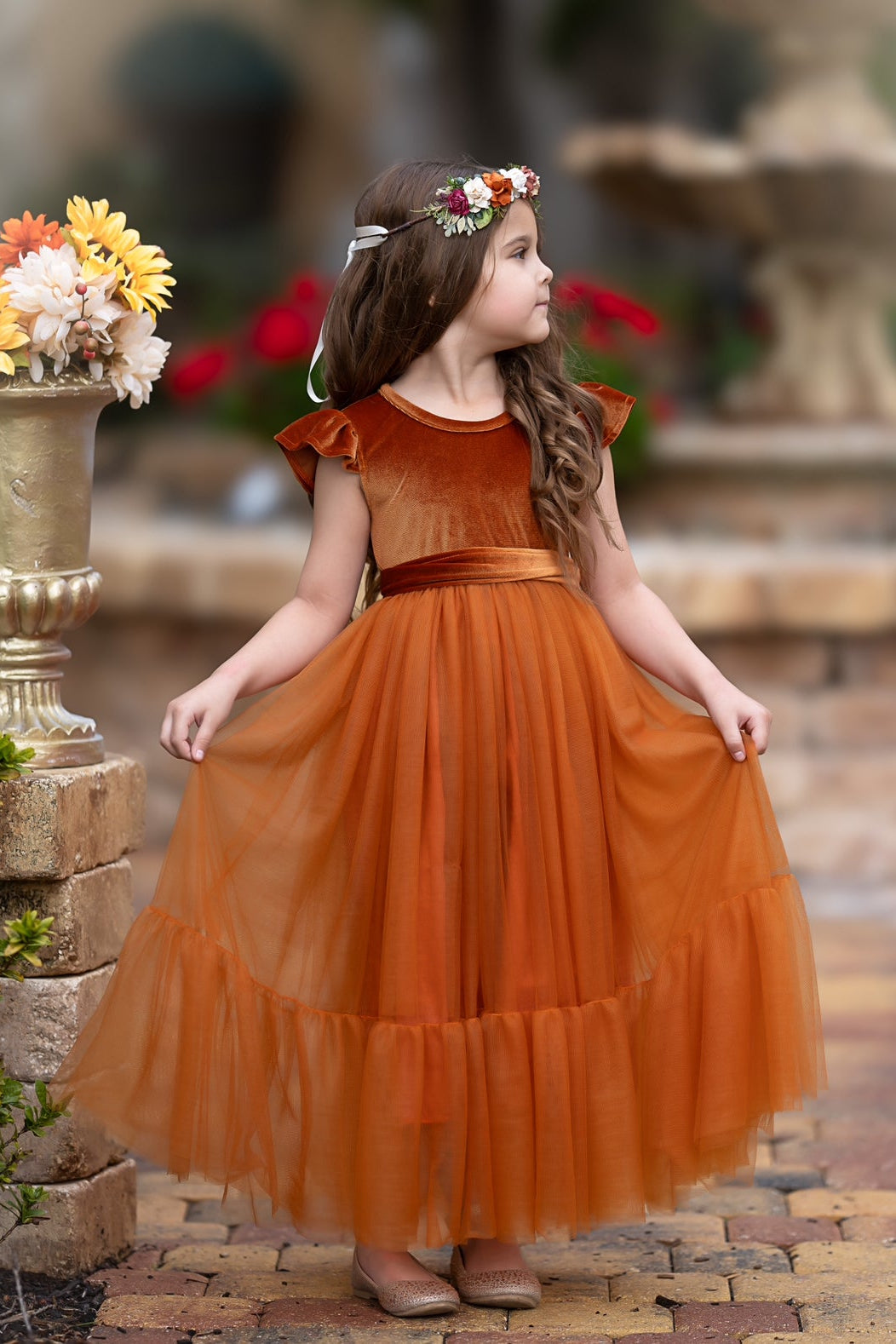 Side view of Marcella burnt orange velvet flower girl dress with flowing tulle skirt and romantic autumn tone