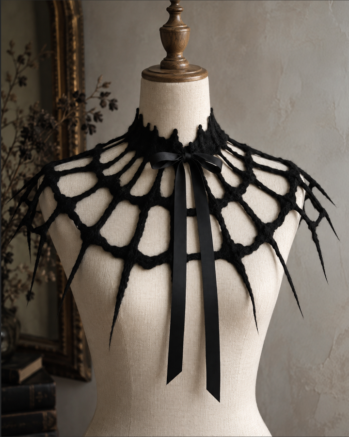 Back view of black spiderweb capelet draped across the shoulders