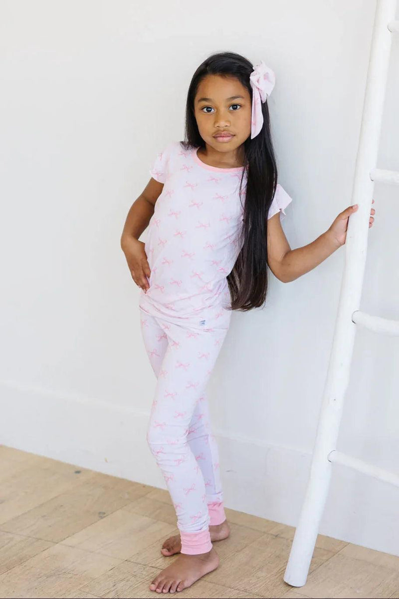 Front view of pink bows ruffle sleeve bamboo pajamas for girls, two-piece long sleeve top and matching pants.