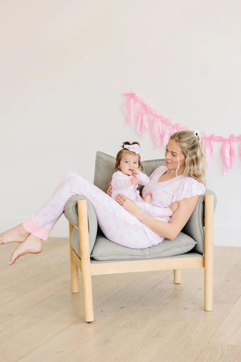 Mom and baby in matching pink bows bamboo pajamas, featuring mommy joggers and baby zipper sleeper.
