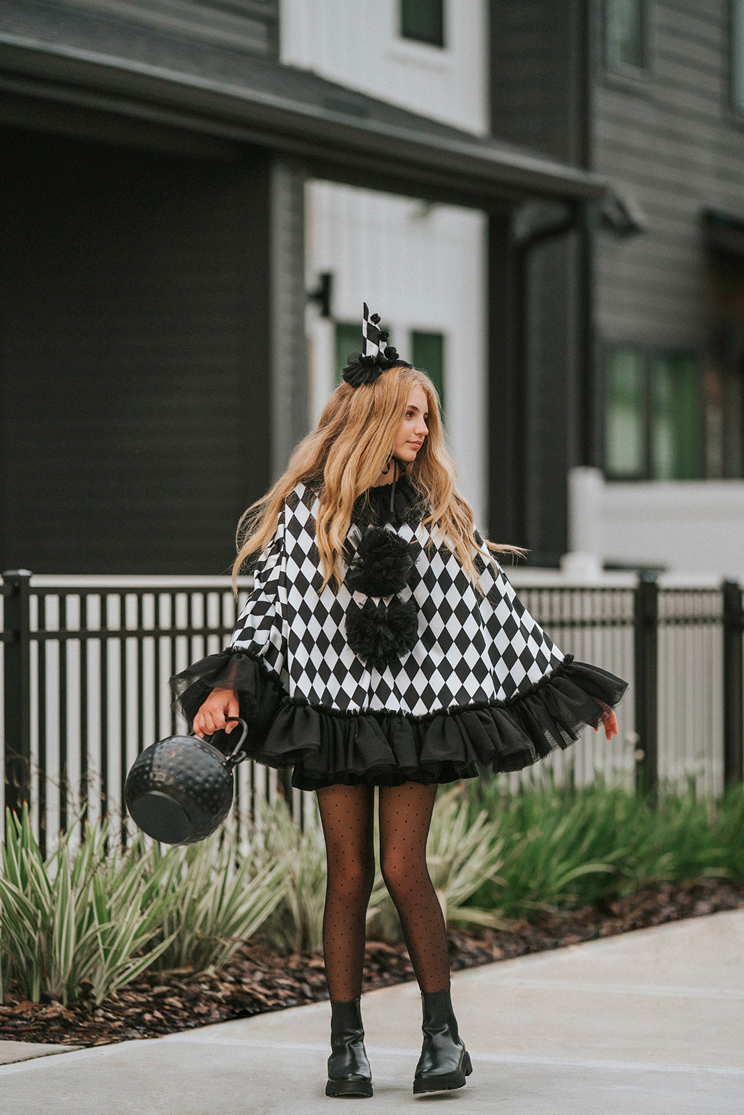 Pirouette harlequin clown cape in motion showing the full black and white satin silhouette and layered black tulle ruffle.