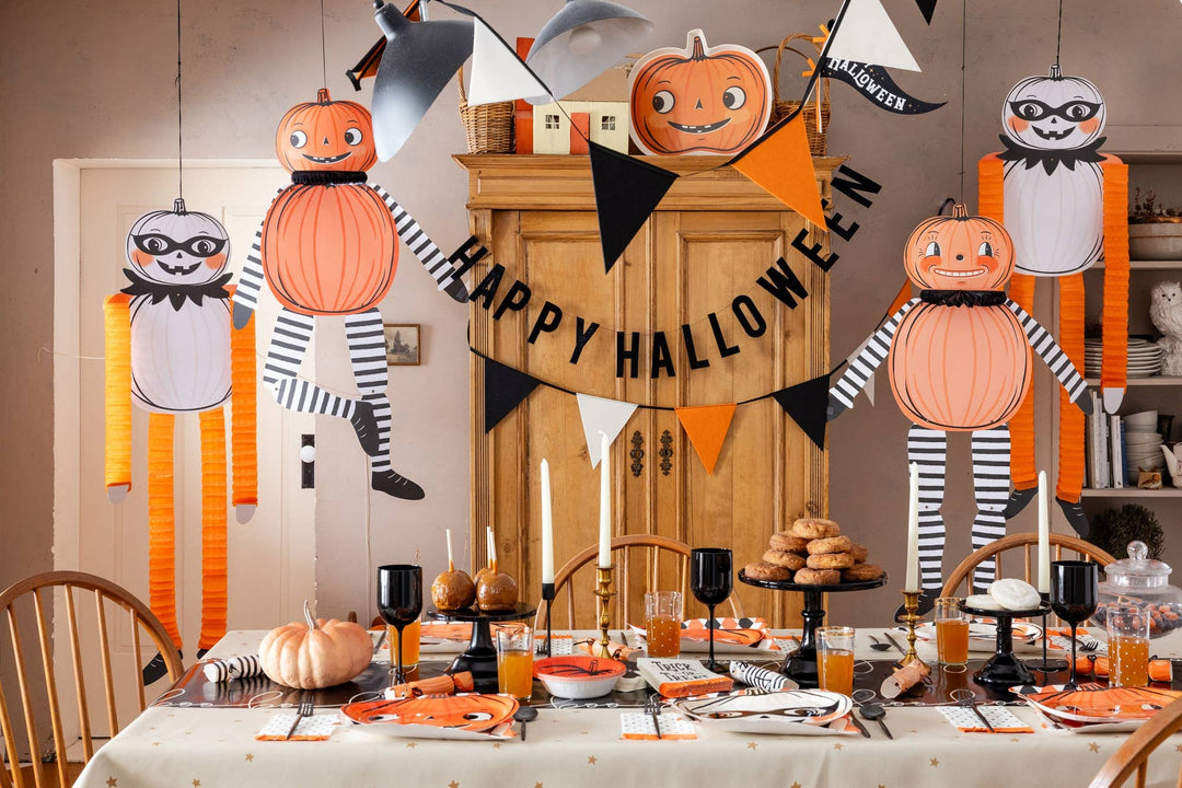 Halloween table setting decorated with vintage black orange and cream felt pennant banner, pumpkins and festive party décor