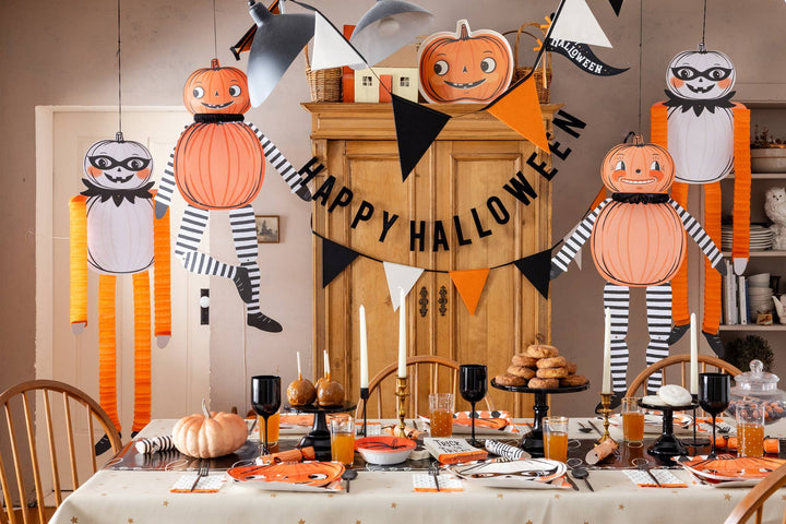 Halloween table setting decorated with vintage black orange and cream felt pennant banner, pumpkins and festive party décor