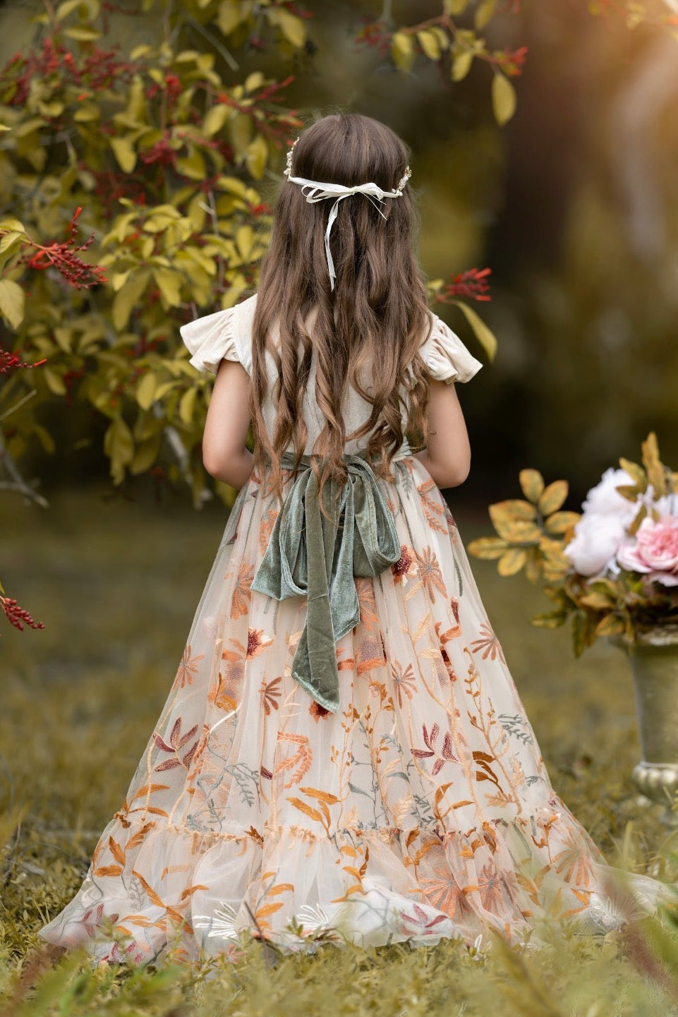 Girl wearing Virelle champagne velvet flower girl dress with full-length embroidered floral tulle skirt outdoors