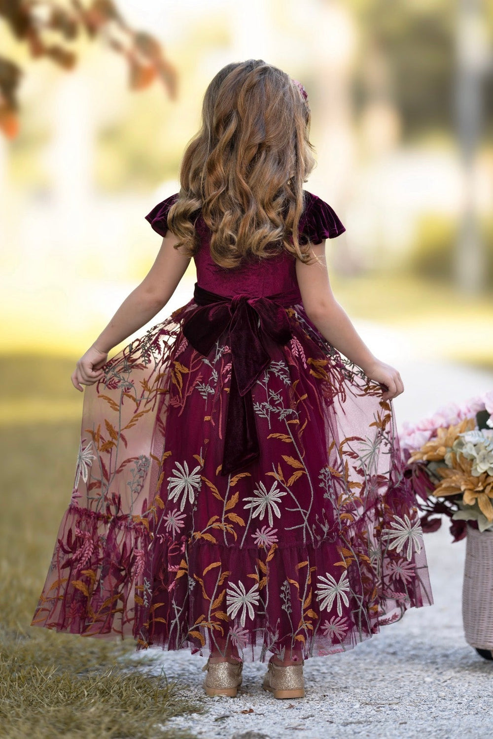 Back view of Virelle dress in bordeaux showing closed-back velvet bodice and sash tie