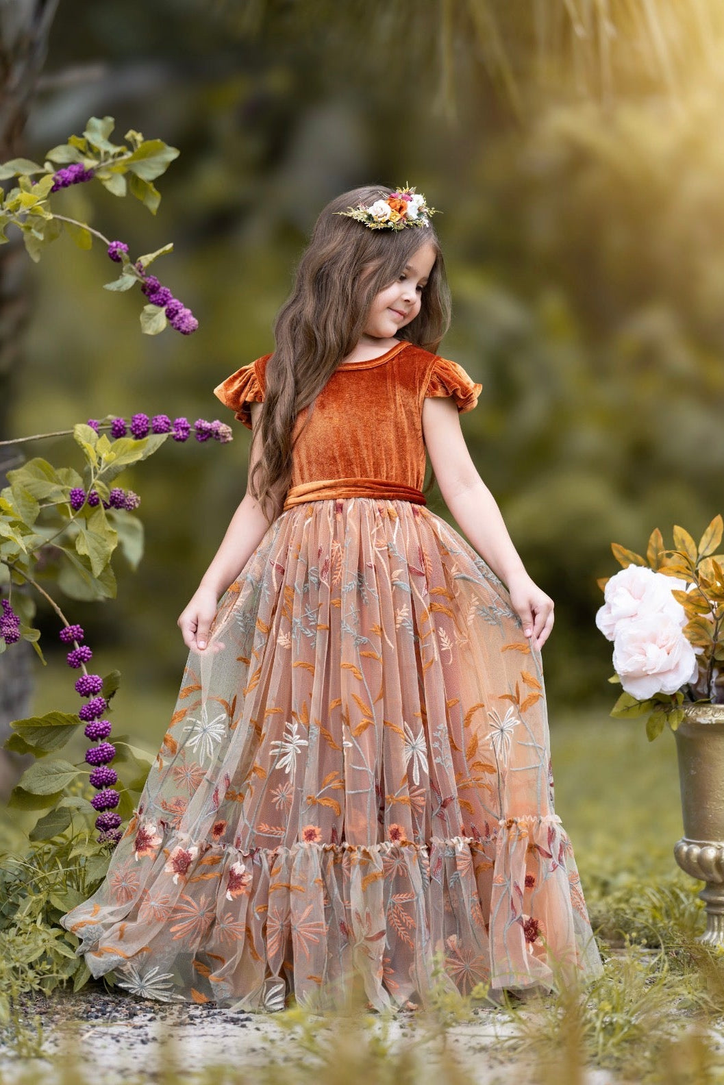 Side view of Virelle gown in burnt orange showing velvet ruffle sleeves and flowing embroidered tulle