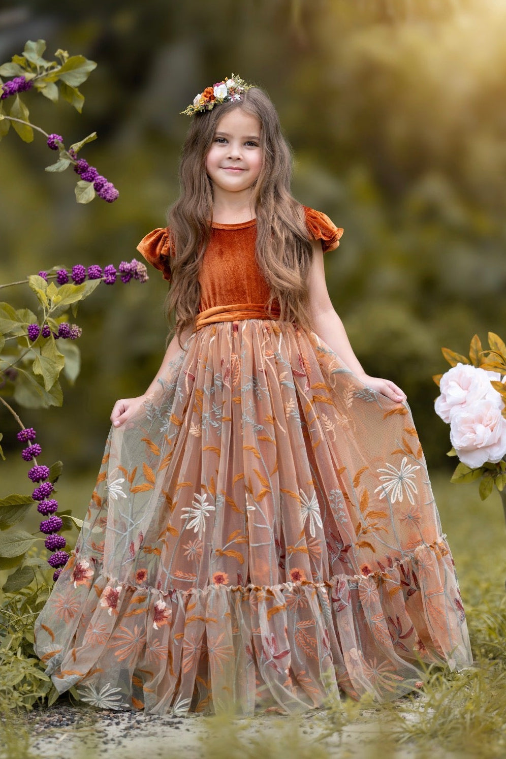 Girl wearing Virelle velvet flower girl dress in burnt orange with full-length embroidered tulle skirt outdoors
