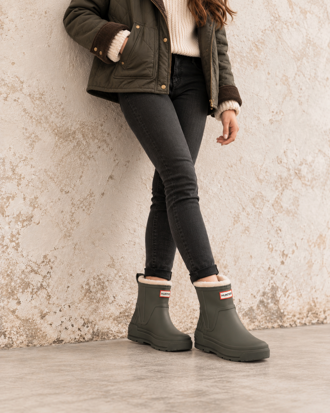 Hunter Women’s Willa olive green insulated waterproof booties styled with black jeans and a shearling jacket