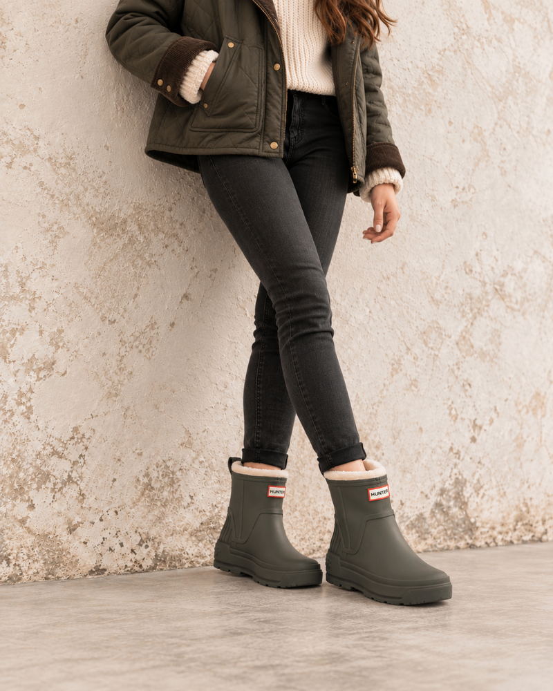 Hunter Women’s Willa olive green insulated waterproof booties styled with black jeans and a shearling jacket