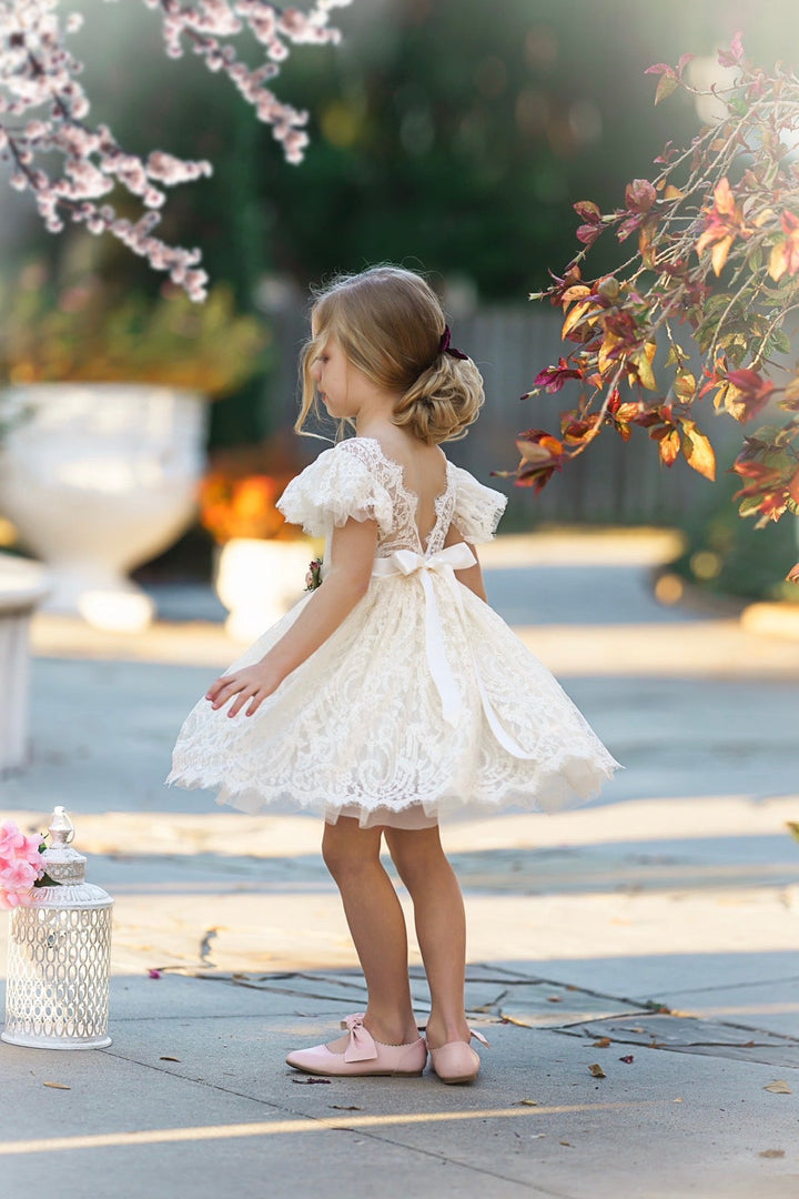 Back view of antique ivory lace flower girl dress with satin sash bow and knee-length skirt, Elowen flower girl dress.