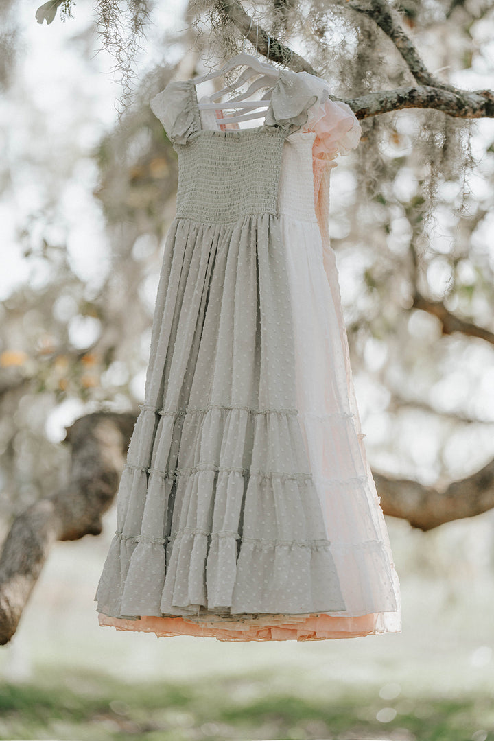 Bay Leaf Orchard Collection girls dress in soft sage green Swiss dot fabric hanging from an oak tree branch.