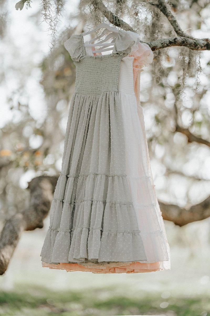 Bay Leaf Orchard Collection girls dress in soft sage green Swiss dot fabric hanging from an oak tree branch.