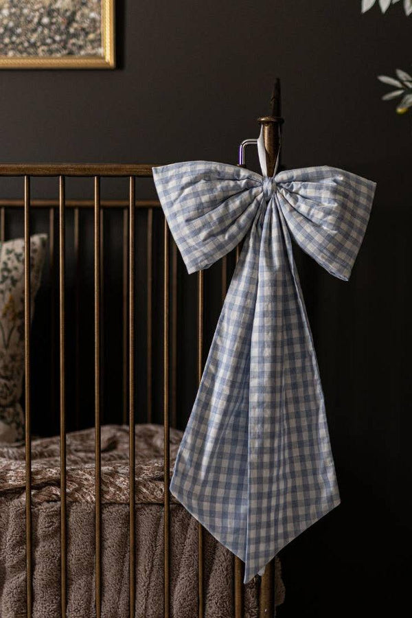 Large baby blue gingham crib bow styled on a nursery crib as timeless heirloom decor.