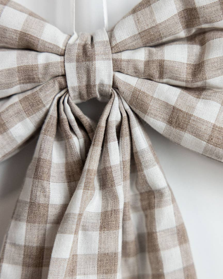 Close-up of beige gingham decorative bow handcrafted from premium cotton fabric.