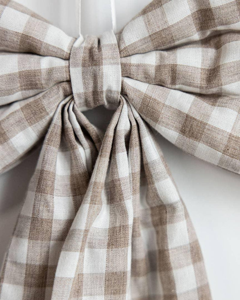 Close-up of beige gingham decorative bow handcrafted from premium cotton fabric.