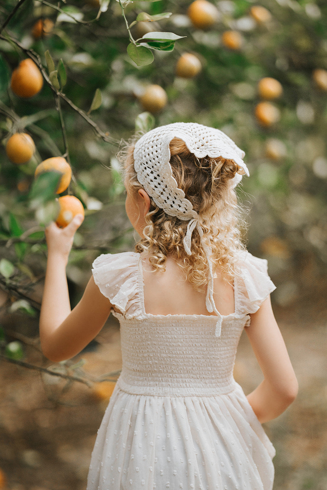 Back view of the Citrus Cream Orchard Dress featuring flutter sleeves and a flowing heirloom-inspired silhouette