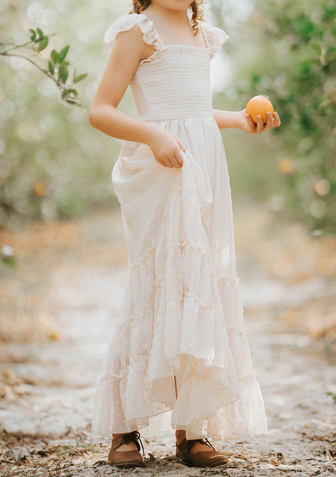 Close-up of the Citrus Cream Orchard Dress featuring a smocked bodice, lined skirt, and heirloom-inspired silhouette