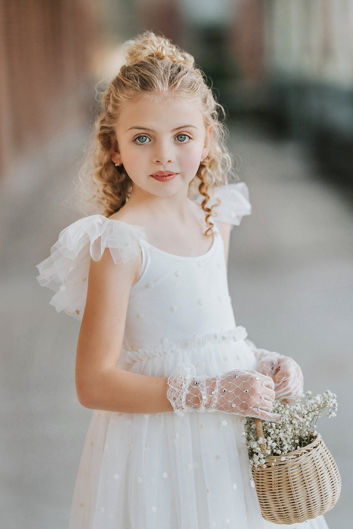 Close up of soft white embroidered floral tulle flower girl dress bodice with delicate ruffle sleeves, heirloom wedding dress detail