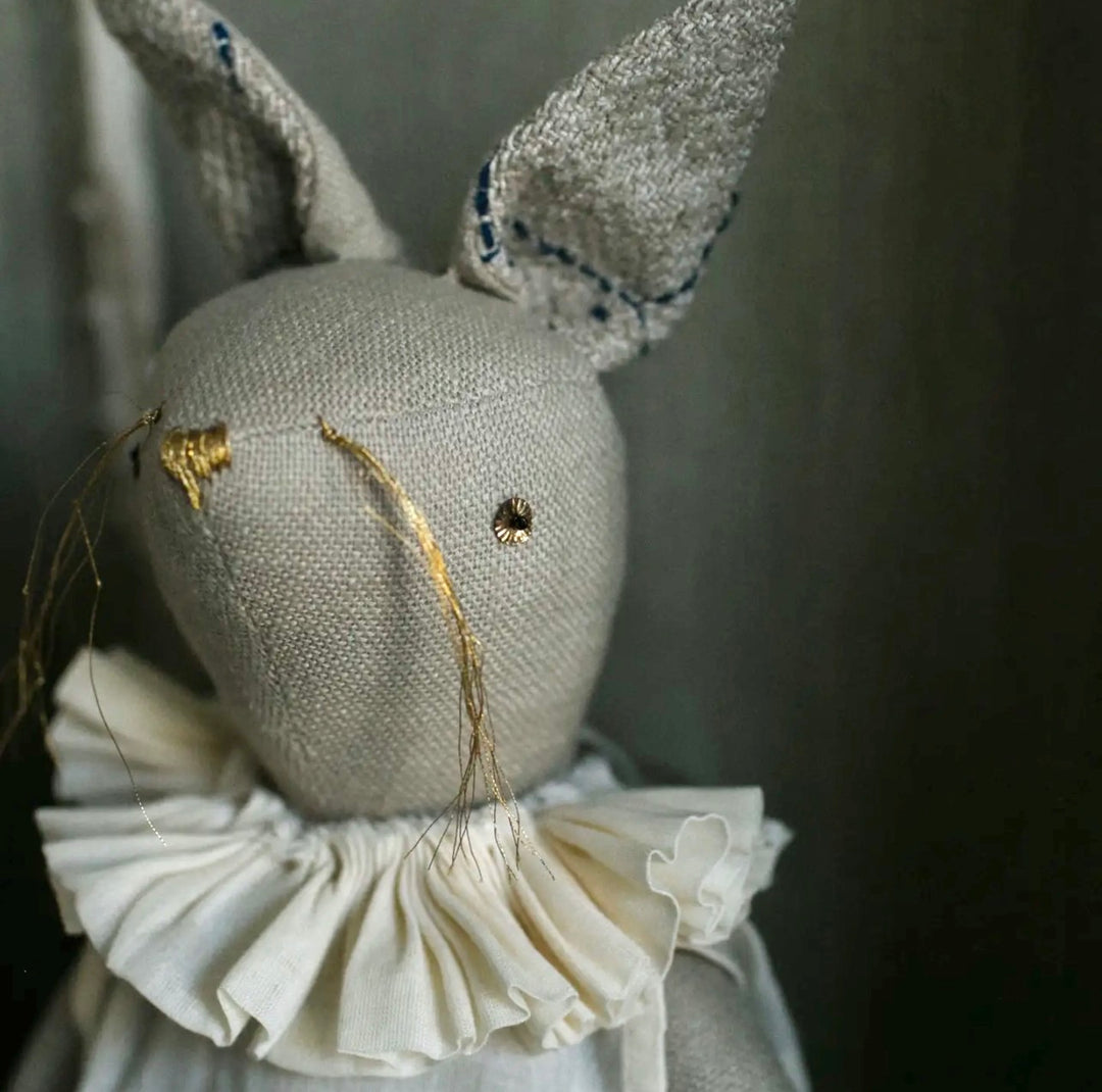 Handmade linen rabbit art doll wearing a soft cotton dress and vintage-inspired ruffle collar