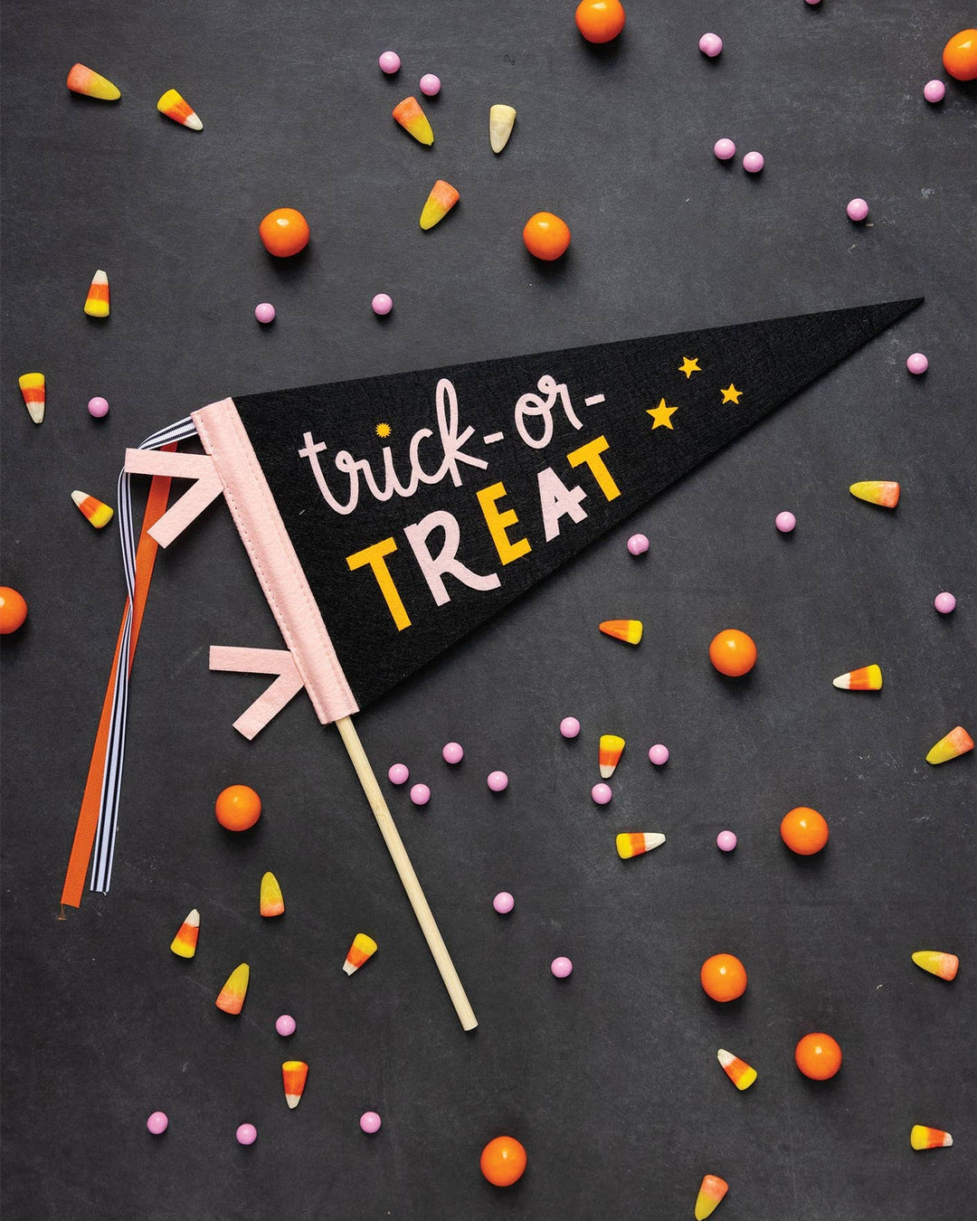 Black Trick or Treat felt pennant banner with pink orange and cream lettering, stars and ribbon streamers.
