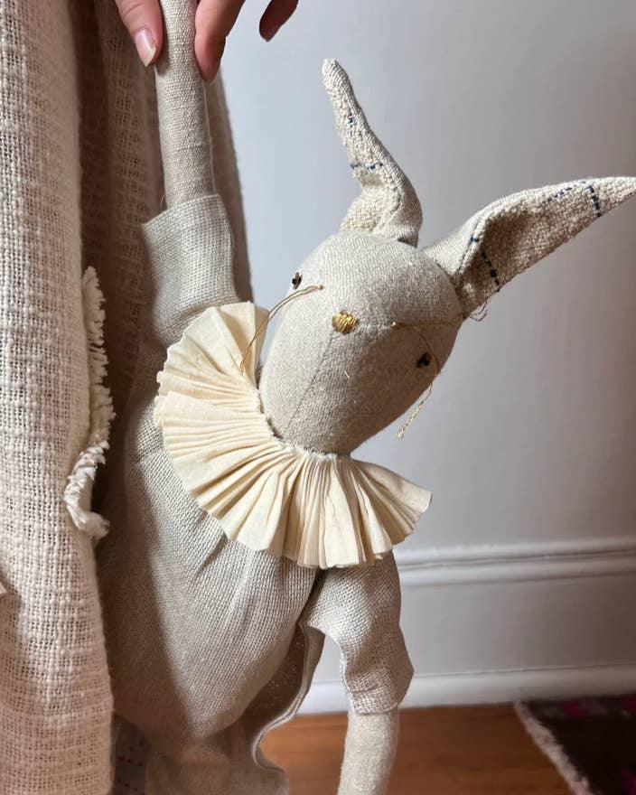 Large heirloom bunny art doll in a lurex linen jumpsuit displayed beside an adult for scale