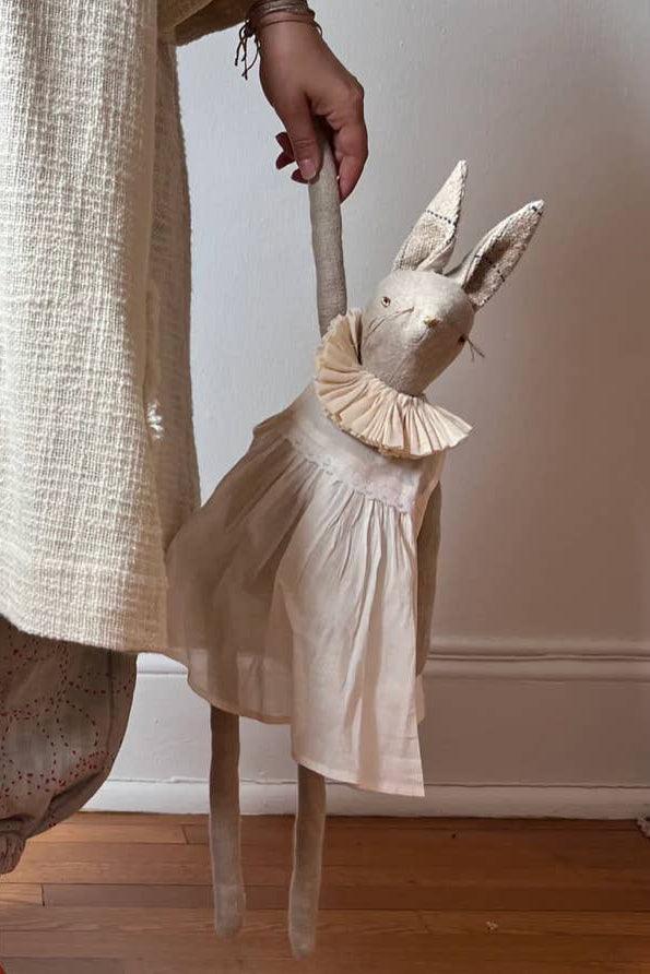 Large heirloom bunny ragdoll in cotton dress displayed beside an adult for scale