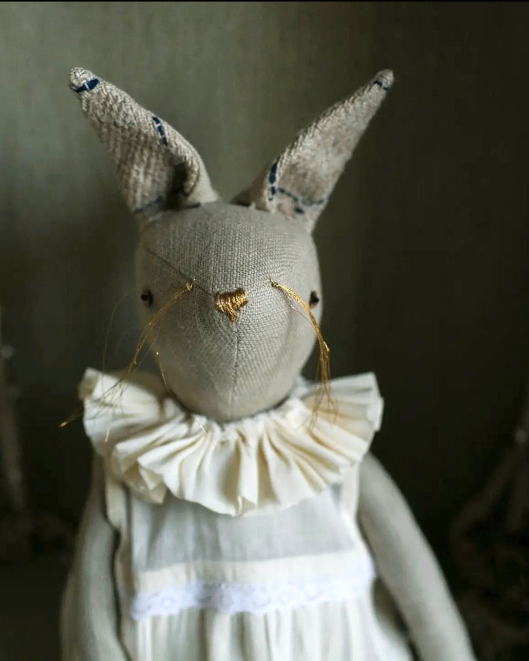 Front view of handcrafted rabbit ragdoll featuring a gathered cotton dress and artisan details