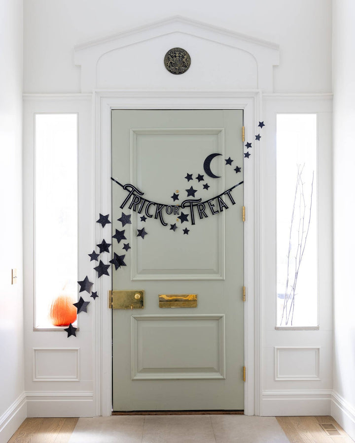 Black felt Trick or Treat Halloween banner displayed with ribbon for hanging