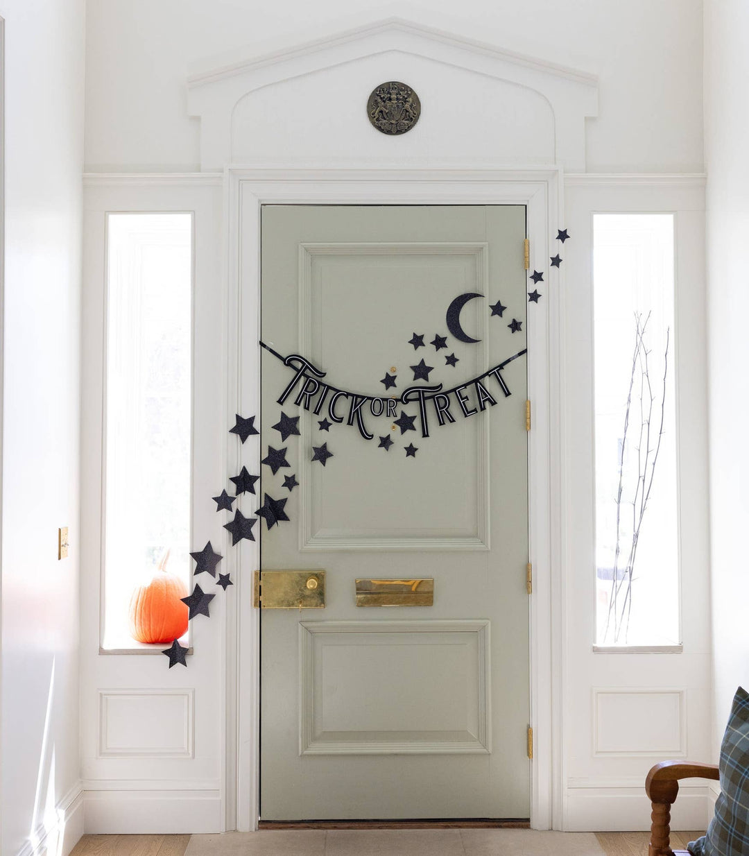 Felt Trick or Treat banner displayed across a front door with pumpkins and Halloween decorations