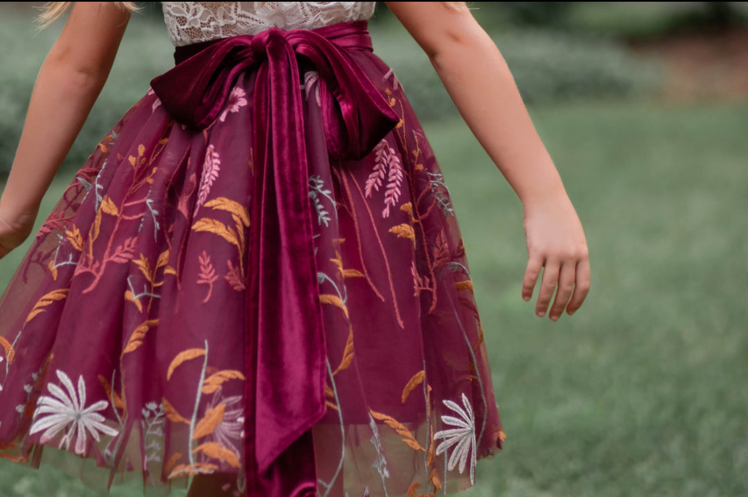 up close photo of the skirting of the bordeaux flower girl dress lace bodice embroidered tulle