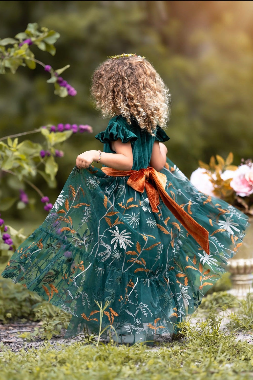 Side view of Virelle girls dress in forest green showing velvet ruffle sleeves and flowing embroidered tulle