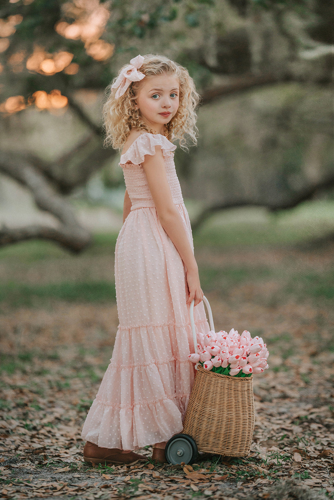 Wild Strawberry Swiss dot girls dress showcasing flutter sleeves and flowing skirt with hair bow