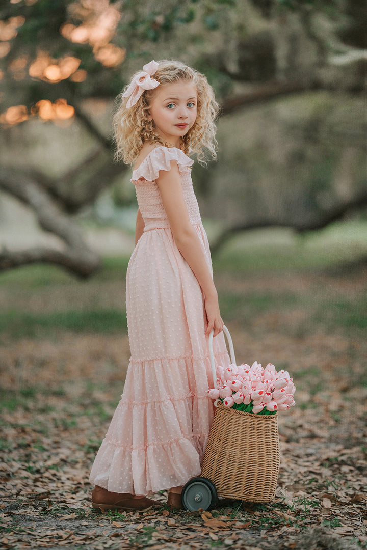 Wild Strawberry Swiss dot girls dress showcasing flutter sleeves and flowing skirt with hair bow