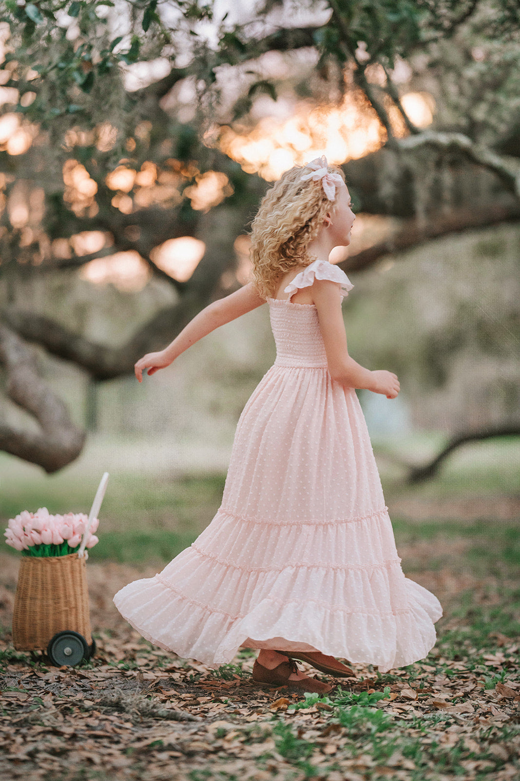 Girl walking in Wild Strawberry Swiss dot maxi dress with ruffle sleeves and full skirt